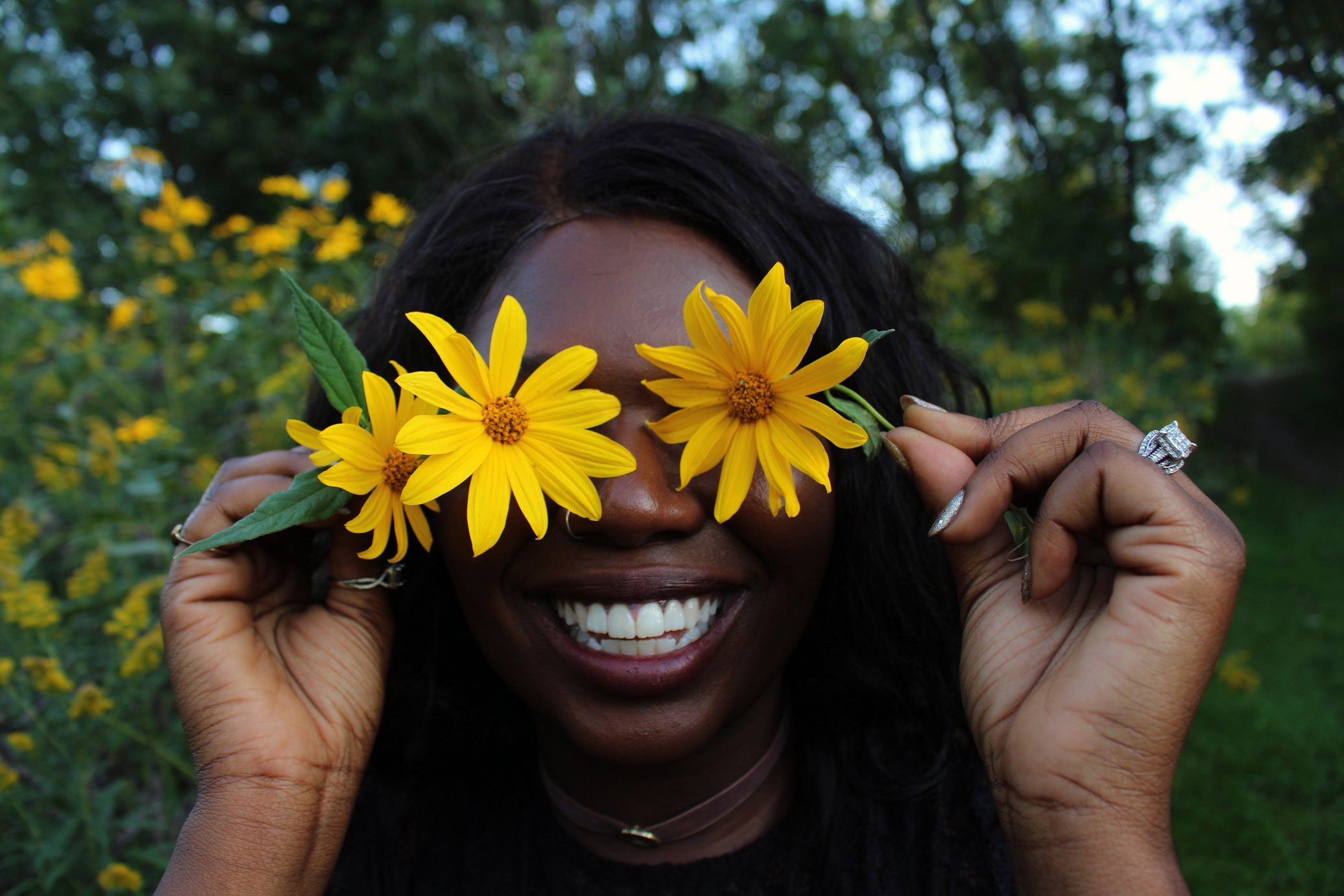 African American woman with flowers in park