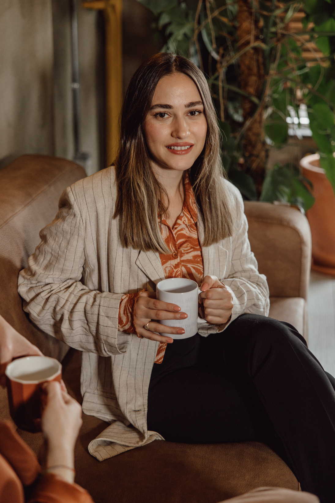 Woman with Cup of Coffee Sitting on Couch